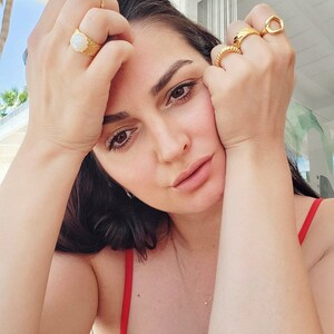 Female model wears chunky gold rings on her hands