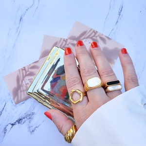 Hand modeling 5 chunky gold rings