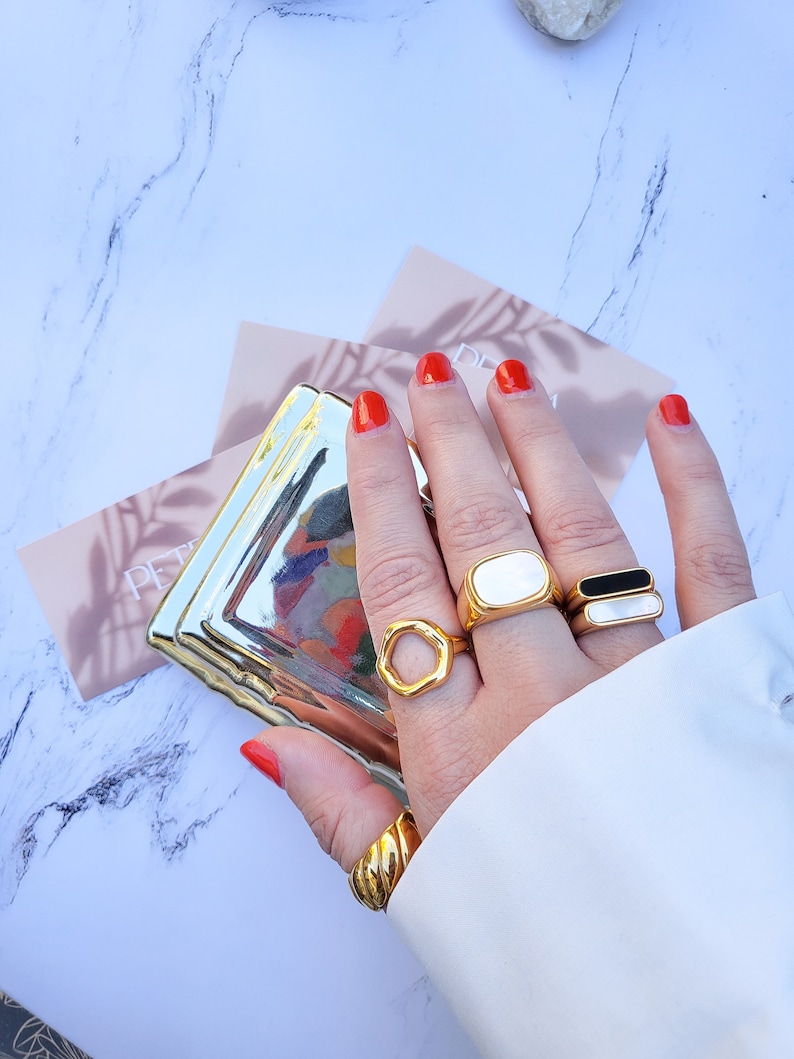 Hand modeling 5 chunky gold rings