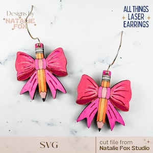 May include: A pair of laser-cut earrings featuring a pencil design with a pink bow. The pencil is yellow and orange with a black tip. The earrings have silver-colored hooks. Text on the image reads "All Things Laser Earrings" and "Designs by Natalie Fox".