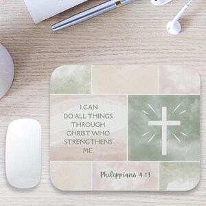 May include: A rectangular mousepad with a watercolor design in pastel colors. The mousepad features a white cross with radiating lines and the text "I can do all things through Christ who strengthens me. Philippians 4:13."