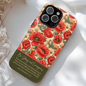 May include: A phone case featuring a vibrant floral design with red poppies and yellow flowers on a cream background. The bottom section is olive green with the text "Be Strong and Courageous" and a Bible verse. The case is designed for a smartphone.