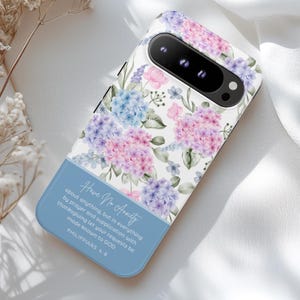 May include: A phone case featuring a floral design with pink, purple, and blue hydrangeas on a white background. The bottom section is light blue with the text "Have No Anxiety" and a Bible verse. The case has a camera cutout.