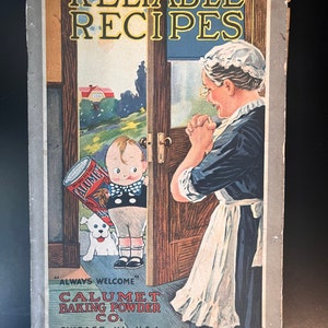 Puede incluir: Una portada de libro de cocina vintage con una mujer con un delantal blanco y un niño sosteniendo una lata de polvo para hornear Calumet. El texto en la portada dice "Recetas confiables" y "Siempre bienvenido Calumet Baking Powder Co. Chicago, Ill., U.S.A."