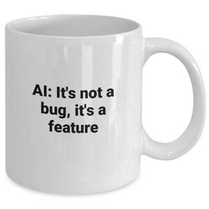 May include: White ceramic coffee mug with black text that reads "AI: It's not a bug, it's a feature".