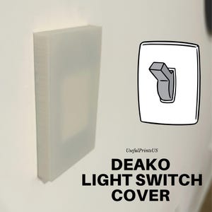 May include: A white plastic light switch cover with the text "DEAKO LIGHT SWITCH COVER" printed below. The cover is designed to fit over a standard light switch.