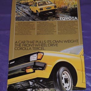 May include: A yellow 1981 Toyota Corolla Tercel car is driving on a dirt road. The car has a black bumper and black trim around the windows. The text "Oh What A Feeling" and "Toyota" are in the upper right corner of the image. The text "A car that pulls its own weight. The front-wheel-drive Corolla Tercel." is at the bottom of the image.