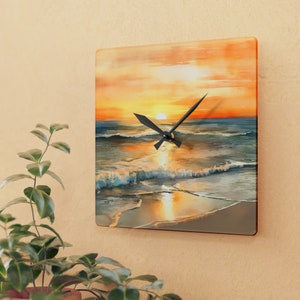 Puede incluir: Reloj cuadrado de vidrio con una imagen de acuarela de una puesta de sol sobre el océano. Las manecillas del reloj son negras y el fondo es un degradado de naranja, amarillo y azul.
