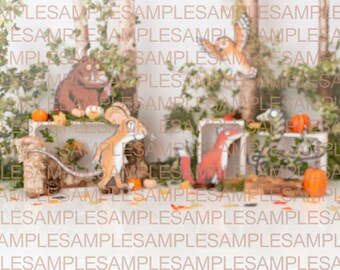 May include: A woodland-themed backdrop for a photo shoot, featuring a brown and orange Gruffalo, a brown and white mouse, a red fox, an owl, and pumpkins. The backdrop is decorated with greenery and fall leaves.