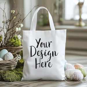 May include: White tote bag with black text that says "Your Design Here". The bag is sitting on a wooden surface with Easter eggs in the background.