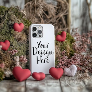 May include: White phone case with a camera lens and the text "Your Design Here" surrounded by red hearts and moss.