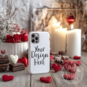 May include: White iPhone case with a black design that says "Your Design Here" on a wooden surface with red hearts, chocolate, and candles.