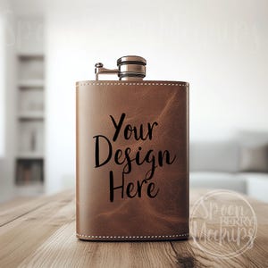Puede incluir: Frasco de cuero marrón con tapa plateada y el texto "Your Design Here" impreso en la parte delantera.