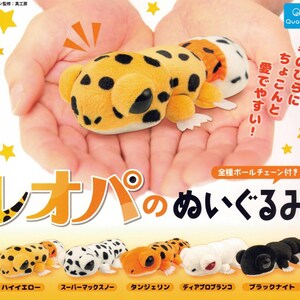 May include: A plush leopard toy in a person's hands, with a yellow body and black spots. The image includes text in Japanese and several other plush leopard toys in different colors.