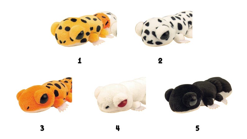 May include: A collection of five plush toy animals in a row. The toys include a leopard, a Dalmatian, an orange lizard, a white bear, and a black bear. Each toy has a unique design and color scheme.