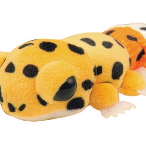 May include: A plush toy caterpillar with a yellow body and black spots. The caterpillar has large, round eyes and small, white feet. The toy is made of soft, fuzzy material.