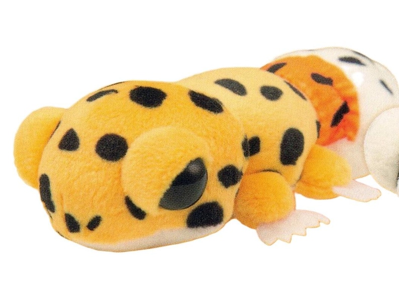 May include: A plush toy caterpillar with a yellow body and black spots. The caterpillar has large, round eyes and small, white feet. The toy is made of soft, fuzzy material.