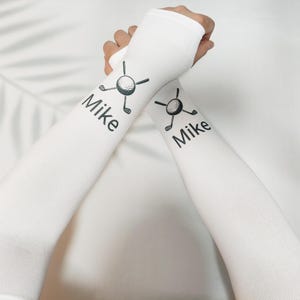 Op de afbeelding: Een set van drie keramische mokken met een gespikkelde, matte afwerking. De mokken zijn in crème, lichtgrijs en donkergrijs. Elke mok heeft een eenvoudig, minimalistisch ontwerp.