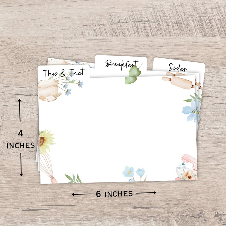 Op de afbeelding: Witte receptkaartsplitsers, 10 cm hoog en 15 cm breed, met bloemen- en keukenthema aquarel illustraties. Tabs lezen "This & That", "Breakfast" en "Sides". Inclusief een zonnebloem, deegroller en mixer.