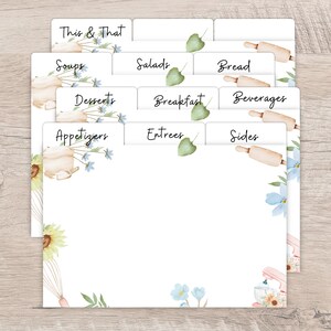 Op de afbeelding: Witte receptkaartsplitsers met bloemen- en bakthema-illustraties. De tabbladen zijn gelabeld met categorie&euml;n als 'Soepen', 'Salades' en 'Desserts'. Het ontwerp bevat aquarel zonnebloemen, deegrollers en mixers.