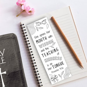 May include: Black and white bookmark with a decorative bow and leaves. The bookmark features a quote from Proverbs 31:26: "She opens her mouth with wisdom and the teaching of kindness is on her tongue."
