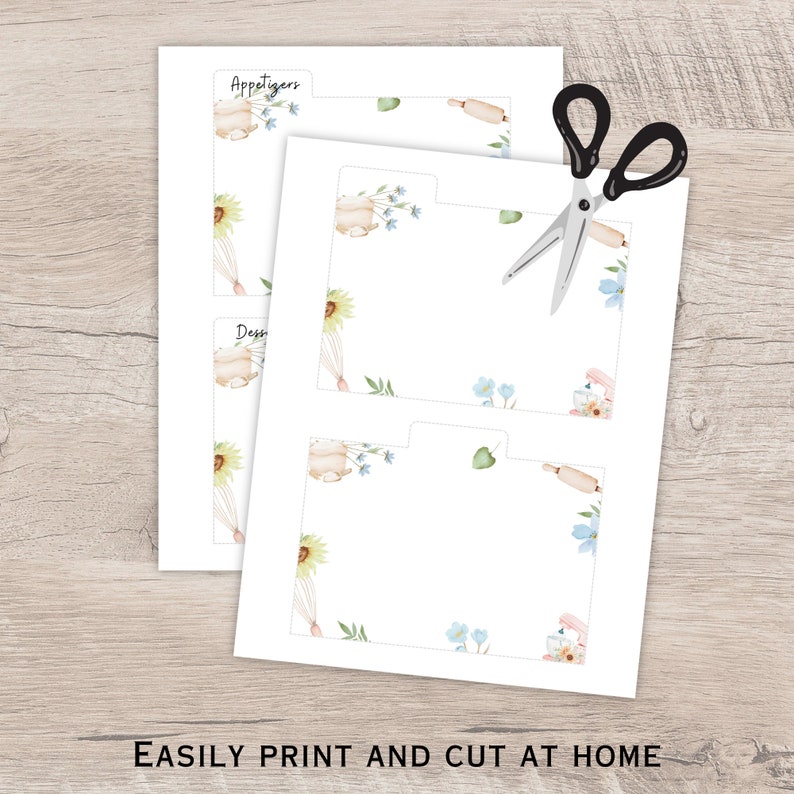 Op de afbeelding: Witte, bedrukbare receptkaarten met aquarel illustraties van keukengereedschap en bloemaccenten. De vellen zijn gelabeld met "Appetizers" en "Desserts". Een schaar ligt bovenop de vellen. De tekst "EASILY PRINT AND CUT AT HOME" staat onderaan.