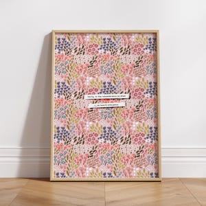 May include: A framed print with a pink floral pattern and a quote in white text: "Verily, in the remembrance of Allah do hearts find peace."