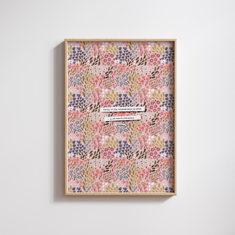 May include: A framed print with a pink background and a floral pattern in shades of blue, green, and red. The print features the text "Verily, in the remembrance of Allah do hearts find peace."