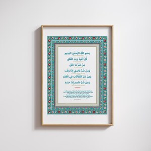 May include: A framed print with a blue and red floral border. The print features a white background with Arabic text in black. The text is a prayer for protection from harm. The text is translated in English below the Arabic text.