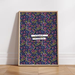 Pu&ograve; includere: Una stampa incorniciata con uno sfondo blu navy e un motivo ripetitivo di fiori rosa e verdi. La stampa presenta il testo "So remember me, I will remember you."