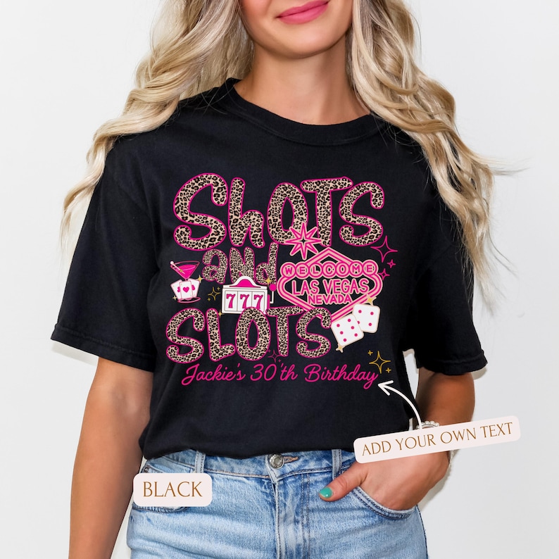 May include: Black t-shirt with a pink and gold design featuring the words "Slots and Slots" with a Las Vegas casino sign and dice. The text "Jackie's 30th Birthday" is also included.