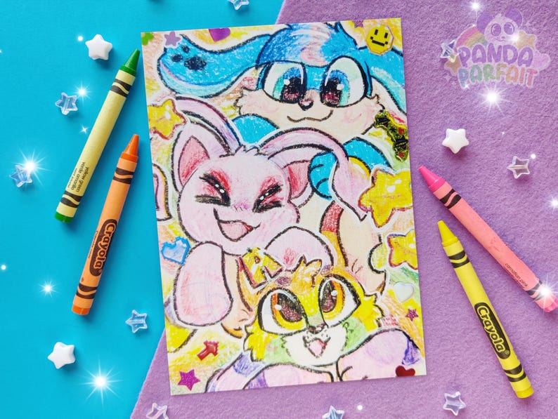 Photo of a 5x7" print of 3 colorful virtual pet characters stacked on top of each other, drawn in crayons. The background is colored paper, crayons, and star beads.