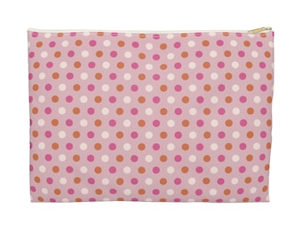May include: A rectangular pink zippered pouch with a repeating pattern of white, orange, and pink polka dots. The zipper is gold-colored. The pouch is likely used for cosmetics or small items.