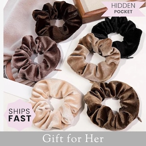 Op de afbeelding: Een verzameling van zes fluwelen scrunchies in verschillende bruin- en beigetinten. De scrunchies liggen op een wit oppervlak, met de tekst "Gift for Her" eronder. De afbeelding bevat ook de tekst "Ships Fast" en "Hidden Pocket".