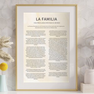 Puede incluir: Una impresión enmarcada con un marco dorado y un fondo blanco. La impresión tiene el título "La Familia" y el texto "Una Proclamación Para El Mundo" en español. El texto está en fuente negra y está centrado en la página.