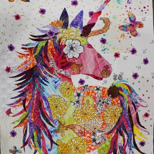 May include: A colorful unicorn design on a white background. The unicorn features a pink face, a rainbow mane, and a spiraled horn. The design includes flowers, butterflies, and other decorative elements in various colors, creating a whimsical and artistic aesthetic.