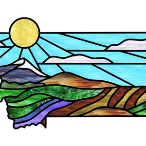 May include: Stained glass artwork featuring a landscape with a sun, mountains, and fields. The colours are blue, green, brown, and yellow.