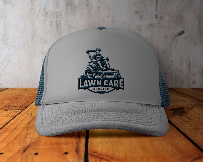 May include: A grey and blue trucker hat with a logo of a person riding a lawnmower with the text "LAWN CARE SERVICE".
