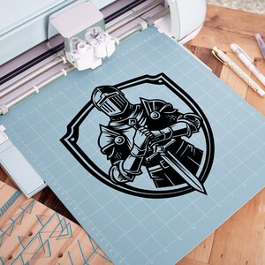 May include: A black and white illustration of a knight in armour holding a sword, inside a shield shape.