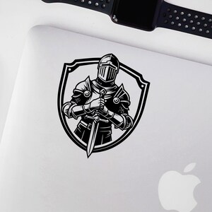 May include: Black and white illustration of a knight in armour holding a sword, standing inside a shield.