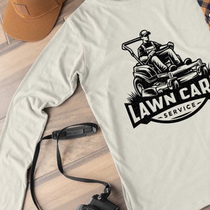 May include: A white long-sleeved t-shirt featuring a black and white illustration of a lawnmower and the text "LAWN CARE SERVICE".