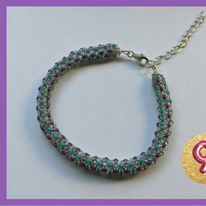 May include: A beaded bracelet with a silver clasp. The bracelet is made with purple, turquoise, and clear beads. The bracelet is 9 inches long.