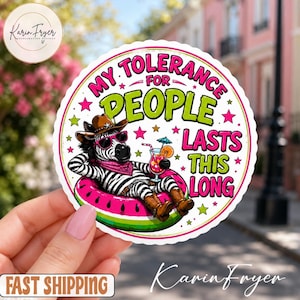 May include: A round sticker featuring a zebra wearing a cowboy hat, sunglasses, and a bandana, lounging in a watermelon-patterned pool float while holding a cocktail. The text reads: MY TOLERANCE FOR PEOPLE LASTS THIS LONG, surrounded by pink and green stars.