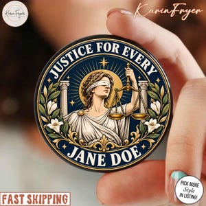 May include: A circular pin featuring a blindfolded Lady Justice holding golden scales, flanked by white columns and floral accents. The dark blue background includes the text JUSTICE FOR EVERY and JANE DOE in bold white lettering with gold trim.
