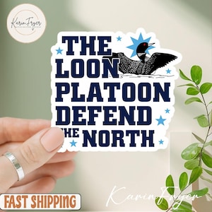 May include: A white sticker with the text "THE LOON PLATOON DEFEND THE NORTH" in navy blue. A black and white illustration of a loon is above the text. Blue stars surround the text and loon.