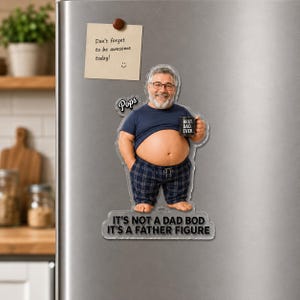 May include: A custom acrylic magnet featuring a caricature of a man with a beard and glasses, wearing a blue t-shirt and plaid pajama pants. The figure holds a mug labeled BEST. DAD. EVER. and includes the text Pops and IT'S NOT A DAD BOD IT'S A FATHER FIGURE.