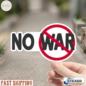 May include: A white sticker with the words "NO WAR" in black, with "WAR" inside a red circle with a red slash. The sticker is held by a hand. The sticker is a magnet.