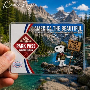 May include: A rectangular America the Beautiful National Parks and Federal Recreational Lands Pass featuring a mountain lake landscape, a red diamond Park Pass Explore Edition logo, and a cartoon dog holding a sign that says Save the Parks.
