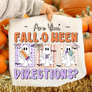 Könnte beinhalten: Cremefarbene Halloween-Grafik mit dem Text "Are You FALL-O-WEEN DIRECTIONS?" in Orange und Lila. Drei Cartoon-Geister sind abgebildet, die jeweils einen Bleistift, ein Buch und einen Globus halten. Fledermäuse und dekorative Bordüren vervollständigen das Design.