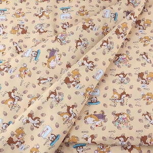 Könnte beinhalten: Ein beigefarbener Stoff mit einem sich wiederholenden Muster von Chip und Dale aus Disneys Chip und Chap: Die Ritter des Tierreiches. Die Figuren sind in verschiedenen Posen dargestellt, darunter beim Laufen, Springen und Halten von Eicheln. Der Stoff zeigt auch den Text "Chip" und "Dale", der sich über die gesamte Oberfläche wiederholt.